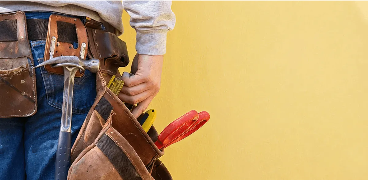 Handyman with tool belt ready for home repairs and maintenance in Des Moines, IA